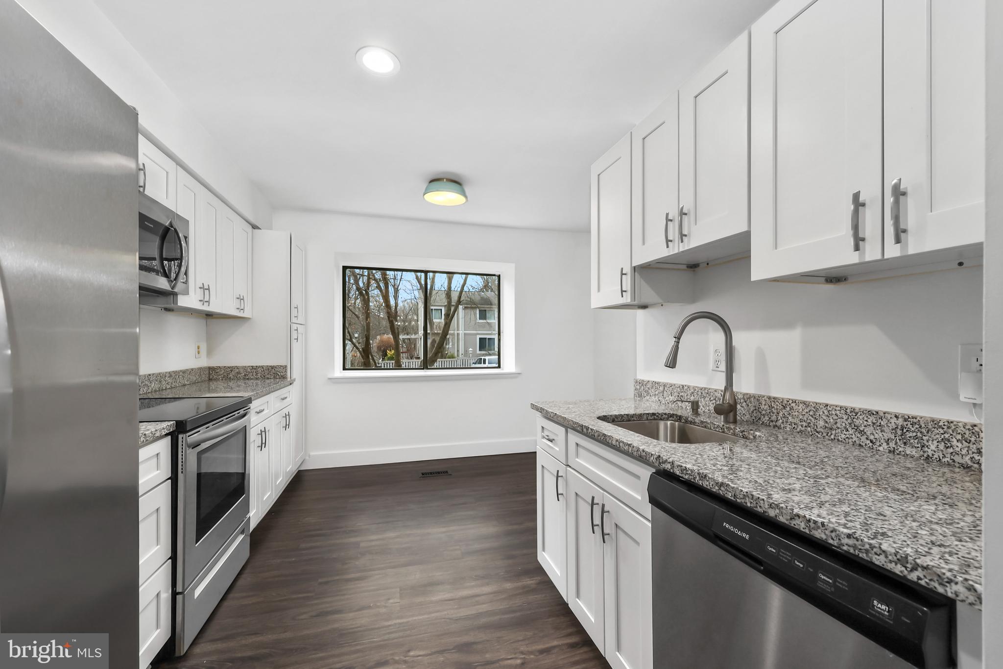 11711 Decade Court Reston, VA 20191 - Photo 7 of 44 a kitchen with granite countertop a sink stove and cabinets