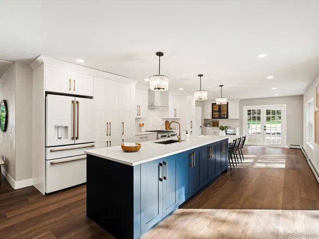 a kitchen with stainless steel appliances kitchen island granite countertop a sink a refrigerator and a wooden cabinets