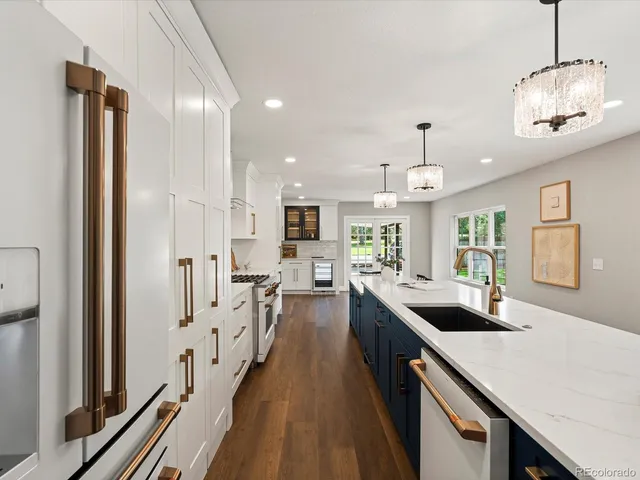 a kitchen with kitchen island stainless steel appliances a stove a sink a counter space wooden floor and cabinets