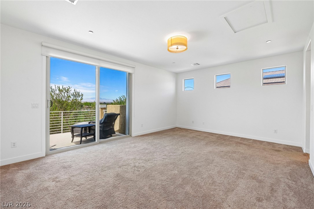 1100 East Sunset Road Henderson, NV 89011 - Photo 30 of 63 Sliding glass doors open from the carpeted room to a private balcony with scenic views.