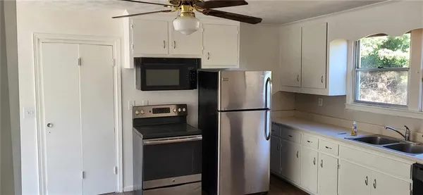 a kitchen with stainless steel appliances a refrigerator sink and microwave