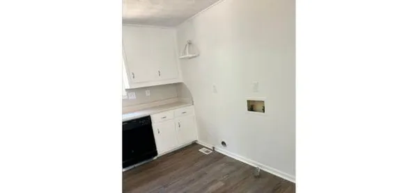 a hallway with a door open and a microwave