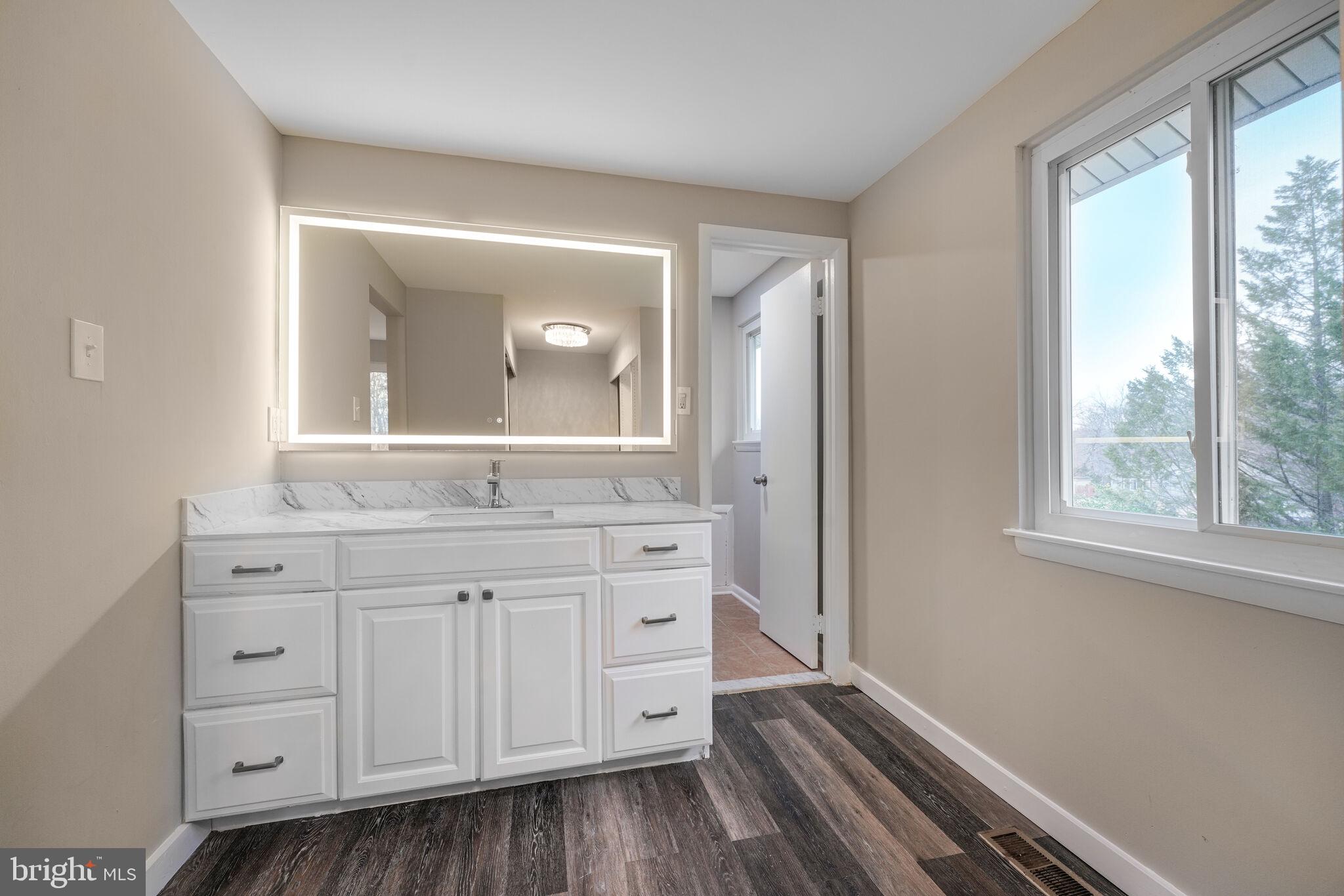 5943 Hall Street Springfield, VA 22152 - Photo 16 of 23 a hallway with white cabinets and wooden floor