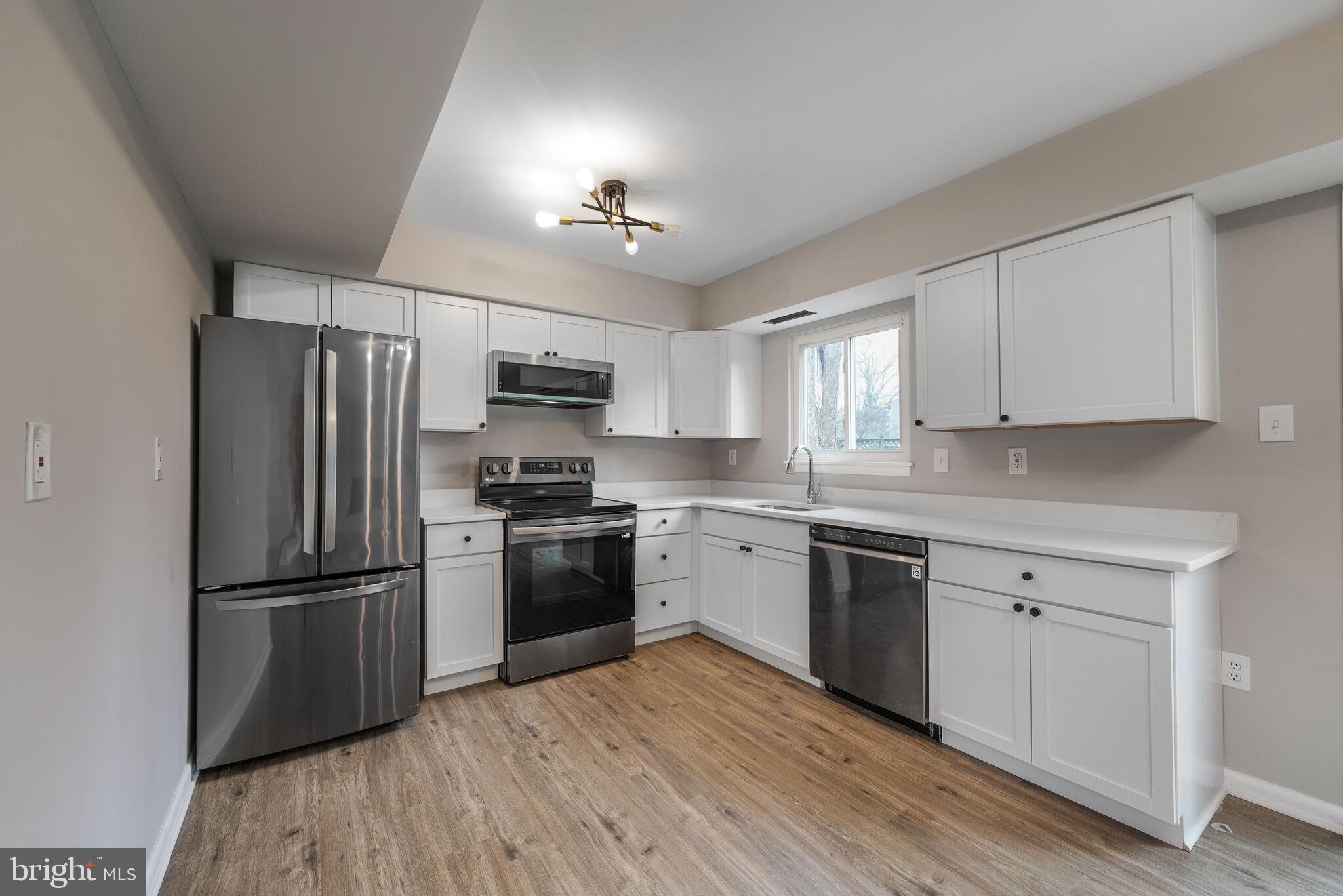 5943 Hall Street Springfield, VA 22152 - Photo 6 of 23 a kitchen with a refrigerator cabinets and wooden floor