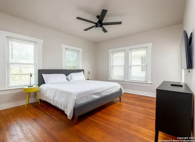 a bedroom with a bed window and a flat screen tv