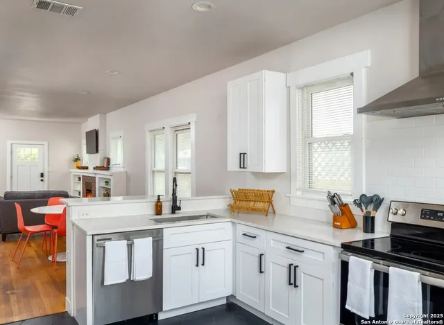 a kitchen with stainless steel appliances granite countertop a sink stove and cabinets
