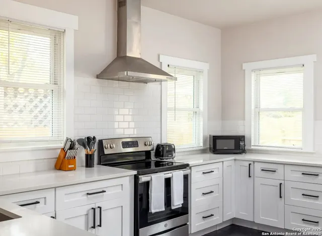 a kitchen with white cabinets and a window
