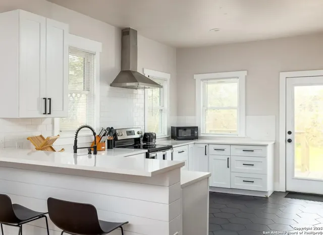 a kitchen with stainless steel appliances a sink a stove and wooden floor