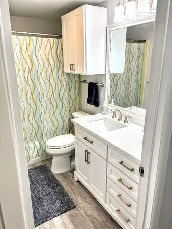 a bathroom with a sink a toilet and a window