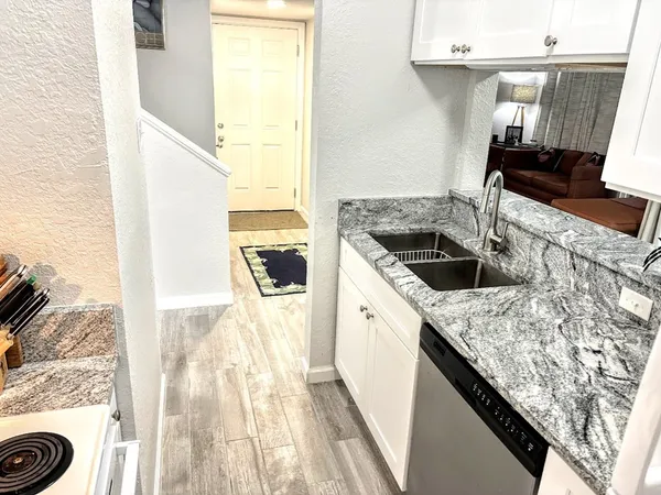 a kitchen with granite countertop a sink and a stove