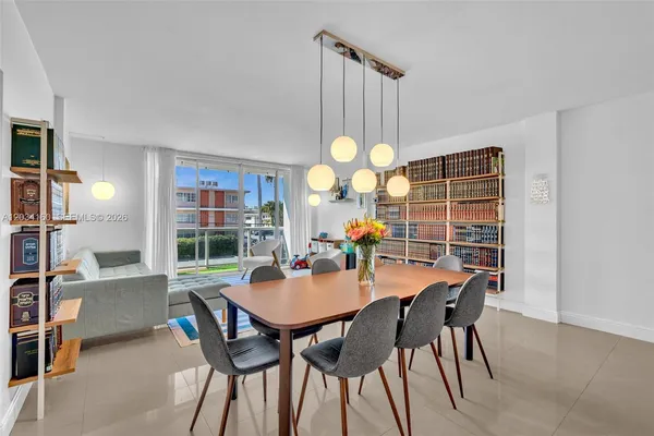 a view of a dining room and livingroom with furniture wooden floor and a rug