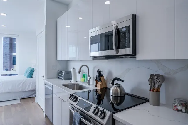 a kitchen with stainless steel appliances granite countertop a sink and stove top oven