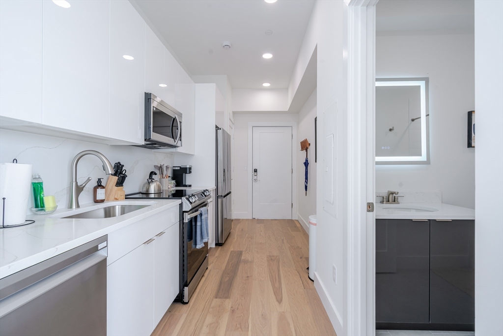 38 Hichborn Street, Unit 401 Boston, MA 02135 - Photo 10 of 11 a kitchen with stainless steel appliances granite countertop sink stove refrigerator and cabinets