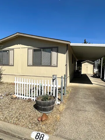 a view of a house with a yard and sitting area