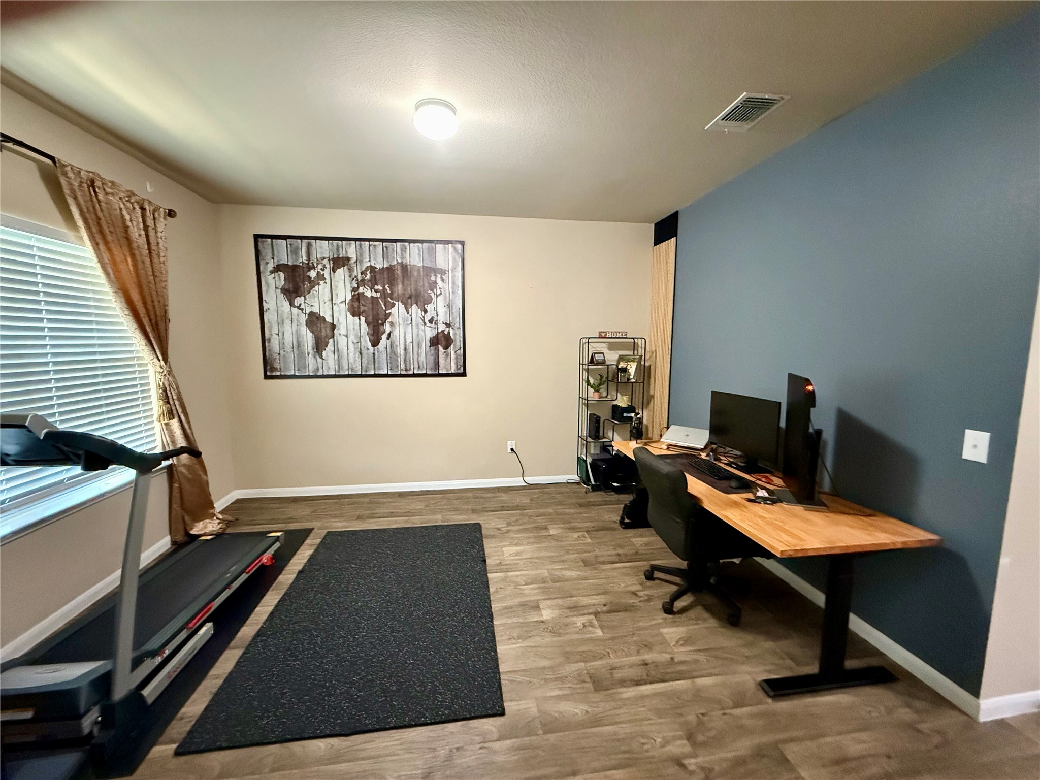 11700 Andesite Road Manor, TX 78653 - Photo 25 of 32 Well-lit room with wood-look flooring provides an adaptable space for a home office or exercise area.