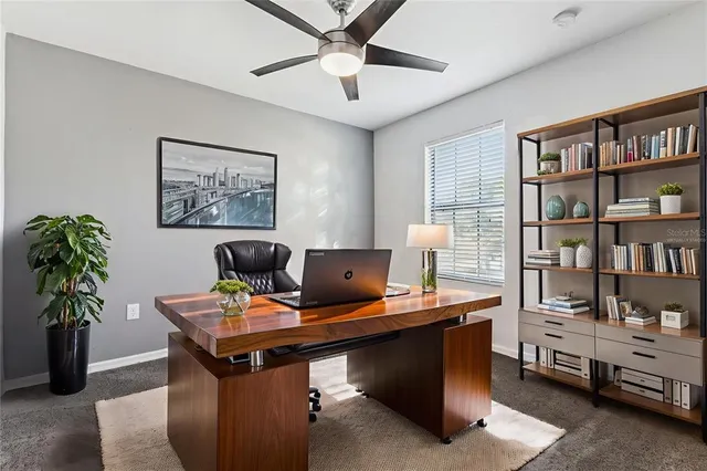 a view of a workspace with furniture and a bookshelf