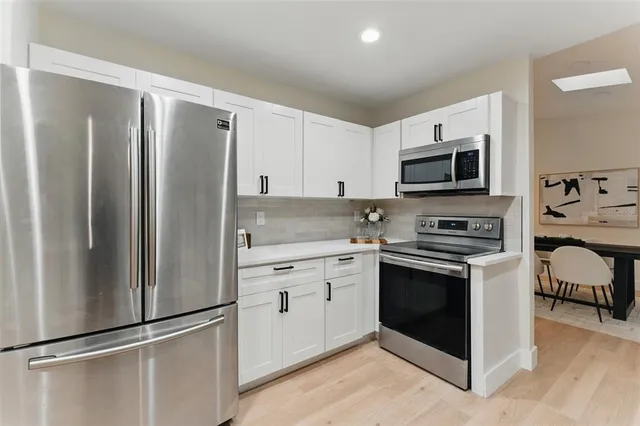 a kitchen with stainless steel appliances a refrigerator sink and microwave