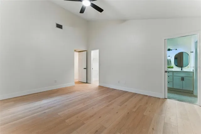 an empty room with a bathroom and mirror