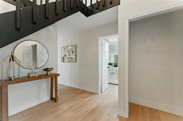 a view of a hallway with wooden floor and a ceiling fan