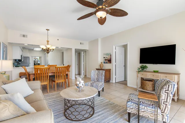 a dining room filled chandelier and kitchen view