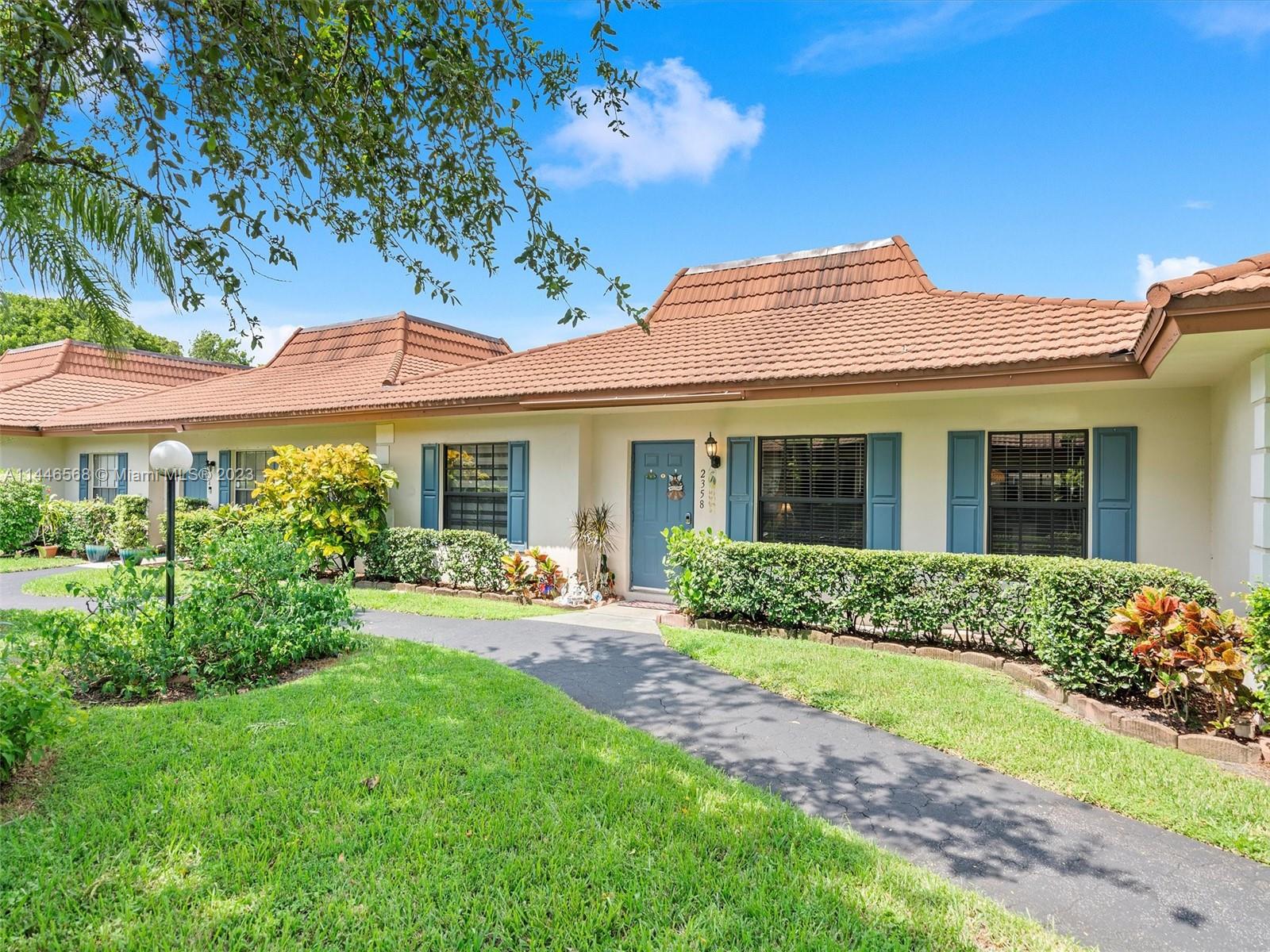 2358 Southwest 70th Way, Unit 6 Davie, FL 33317 - Photo 2 of 55 a front view of a house with garden and porch