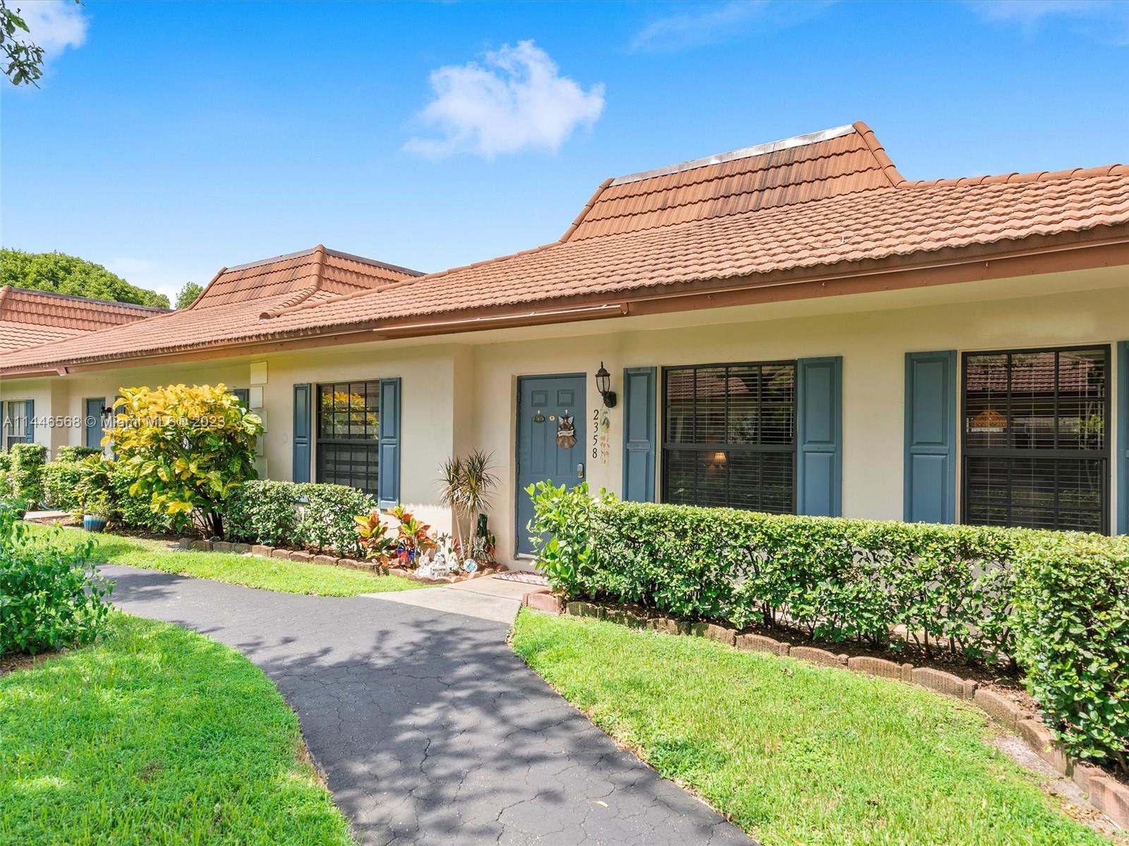 2358 Southwest 70th Way, Unit 6 Davie, FL 33317 - Photo 3 of 55 a front view of a house with a garden and plants