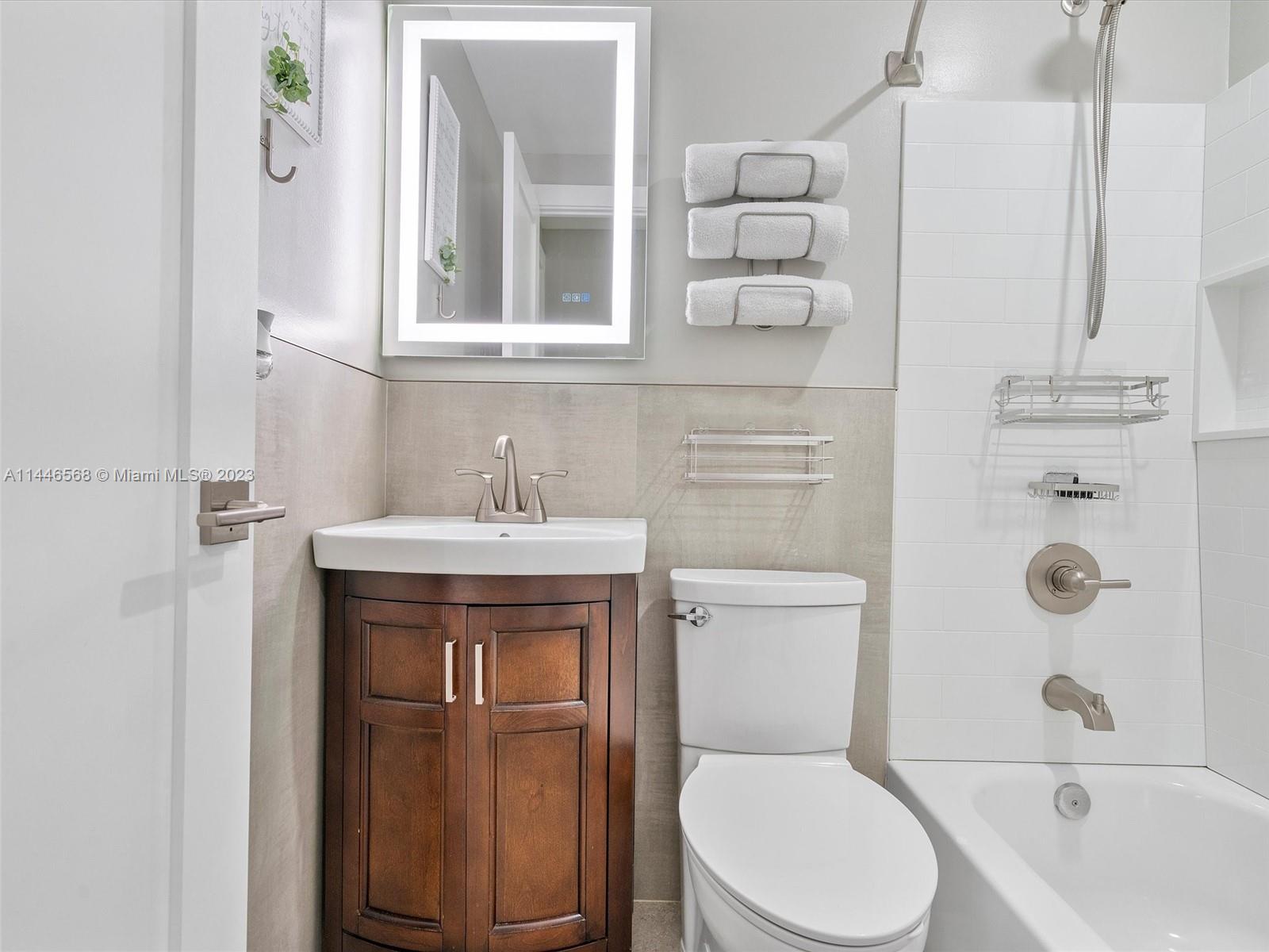 2358 Southwest 70th Way, Unit 6 Davie, FL 33317 - Photo 32 of 55 a bathroom with a toilet sink vanity shower and mirror