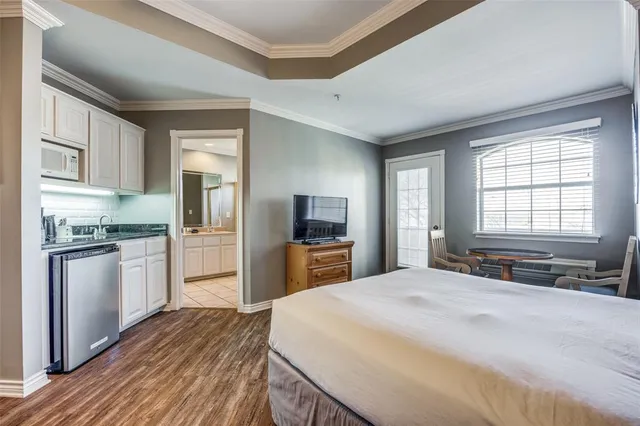 a large bedroom with a bed and a flat screen tv