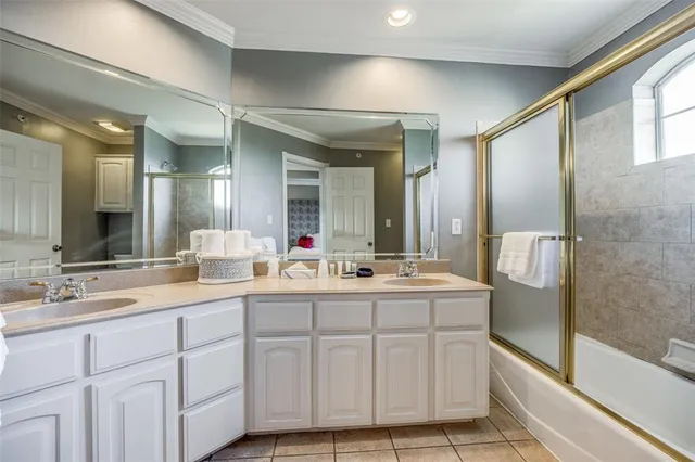 a bathroom with a double vanity sink mirror and bathtub