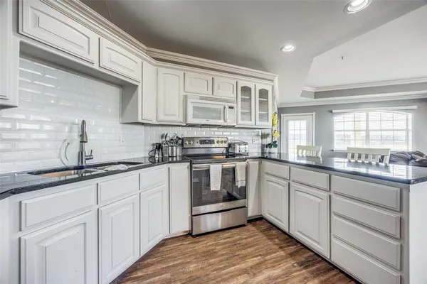 a kitchen with granite countertop white cabinets and white appliances