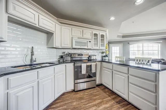 a kitchen with granite countertop white cabinets and white appliances