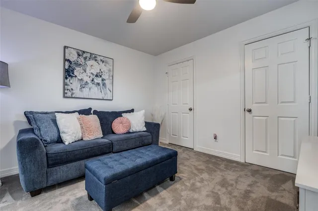 a living room with furniture and a ceiling fan