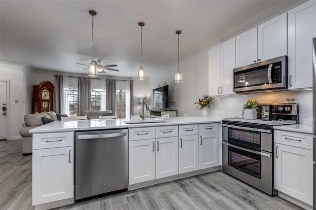a kitchen with stainless steel appliances granite countertop a sink a stove top oven a chimney and cabinets