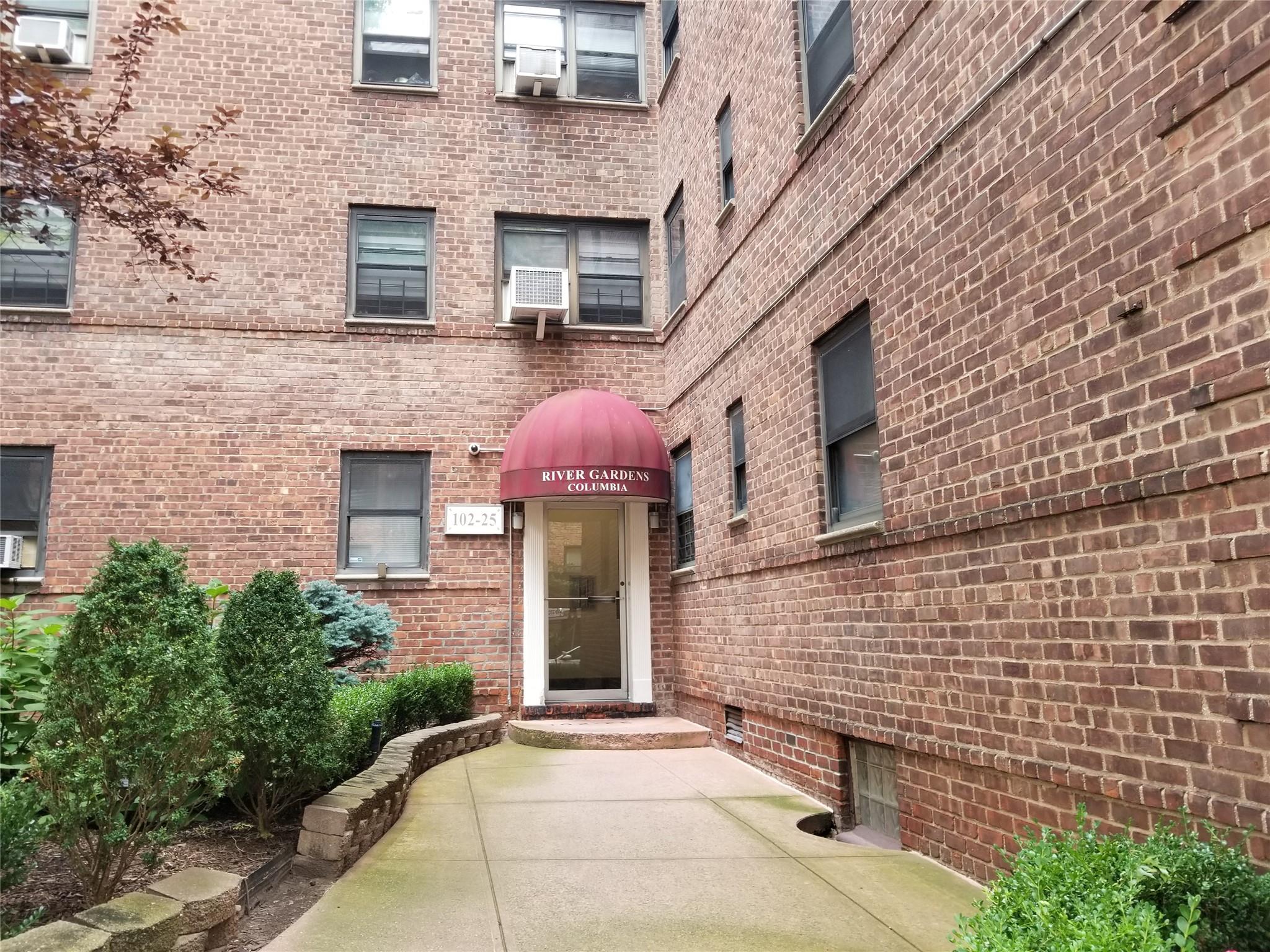 a front view of a house with brick walls and plants