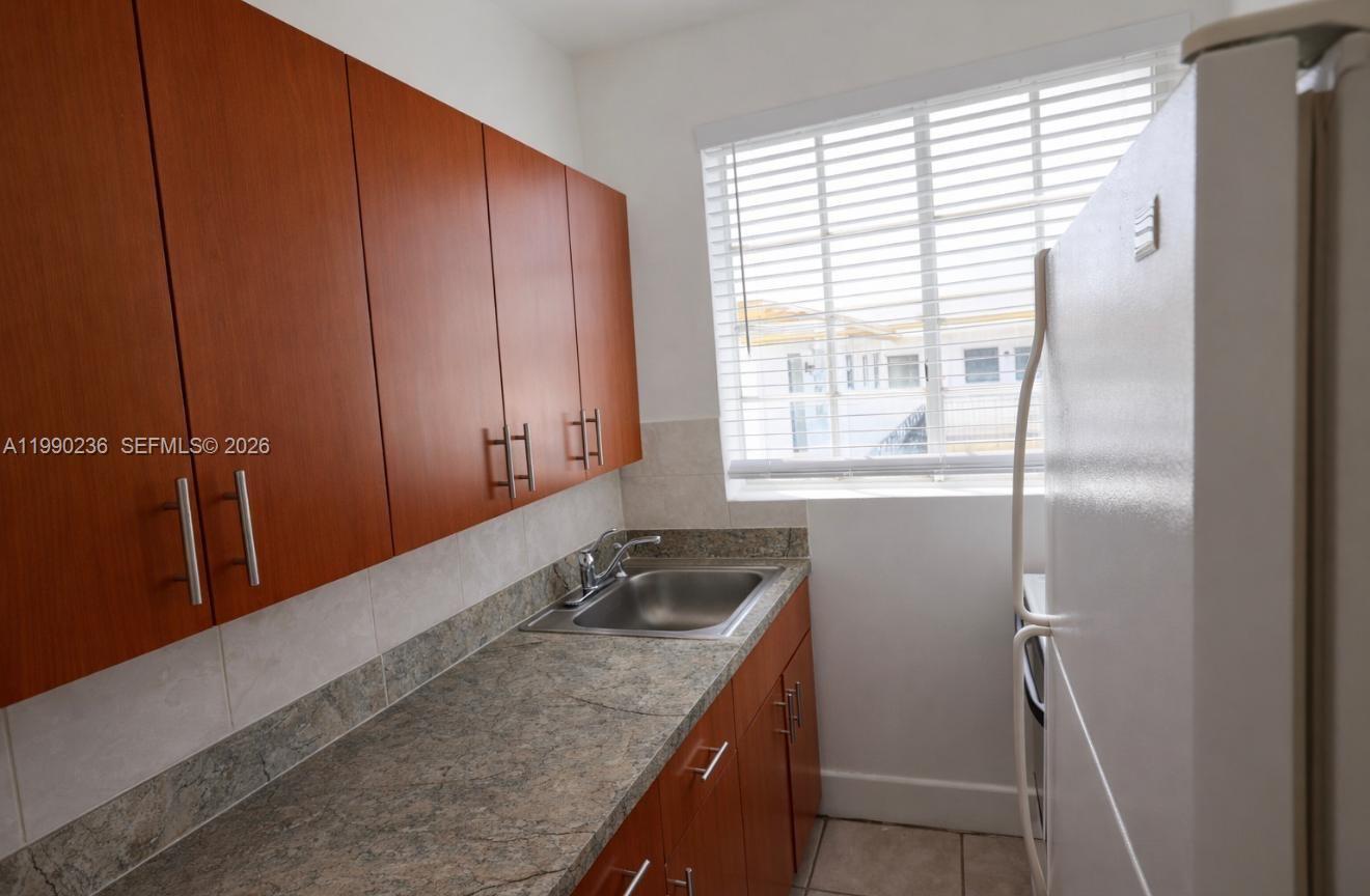 a bathroom with a granite countertop sink and shower