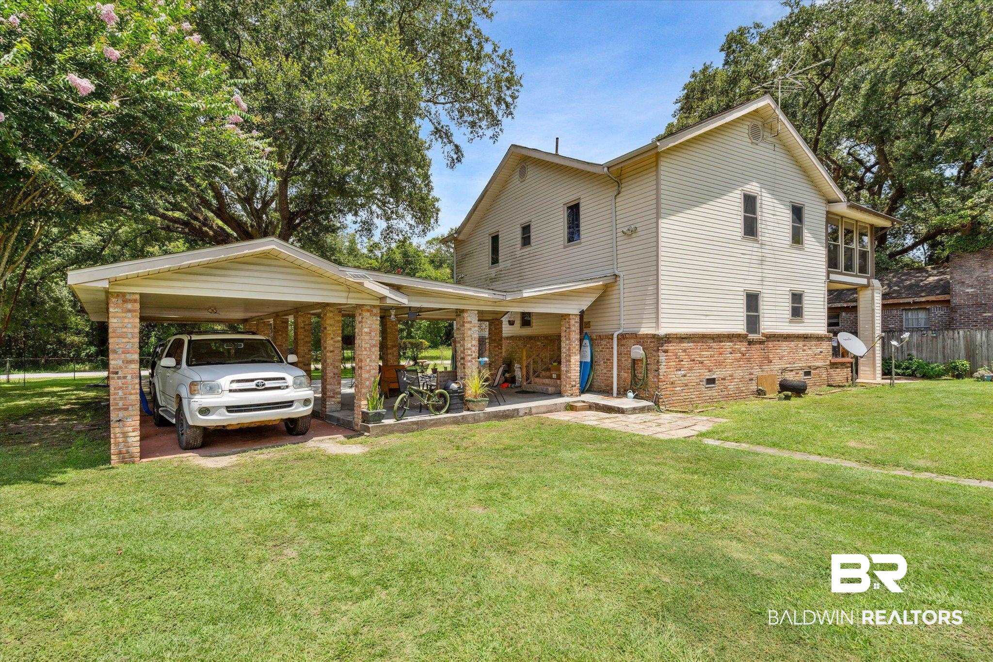 4851 Lesure Road Theodore, AL 36582 - Photo 17 of 21 Back of house with a yard and a carport
