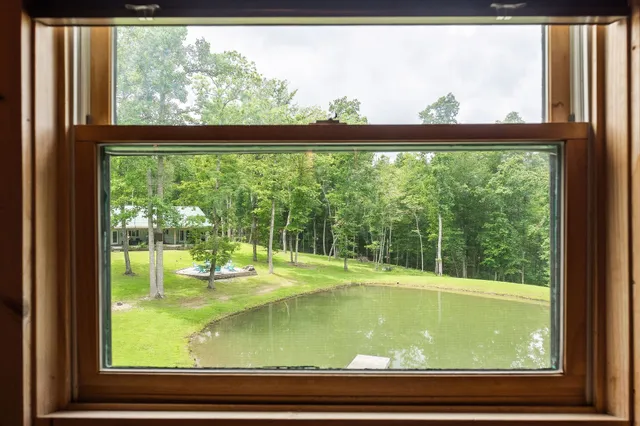 a living room with furniture flat screen tv and a large window