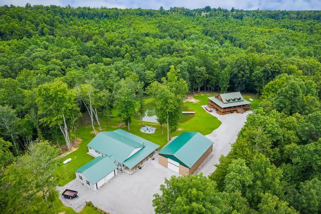 a kitchen with stainless steel appliances granite countertop a stove top oven a refrigerator a dining table and chairs with wooden floor