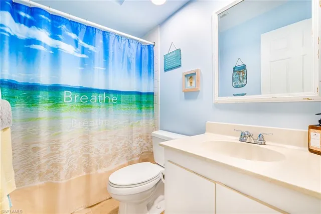 a bathroom with a sink a toilet and a shower curtain