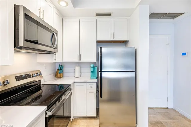 a kitchen with stainless steel appliances a refrigerator a stove top oven a sink and cabinets