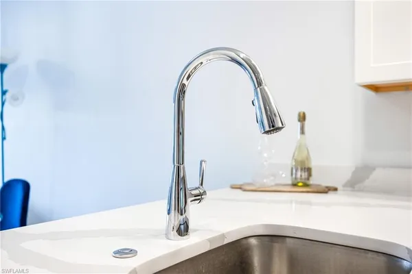 a view with granite countertop a sink and a stove with wooden floor