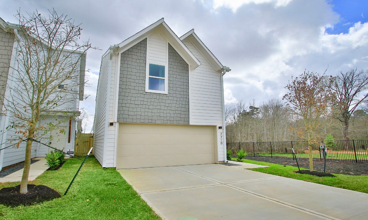 2717 Discovery Trails Conroe, TX 77301 - Photo 2 of 46 a front view of a house with a yard and garage