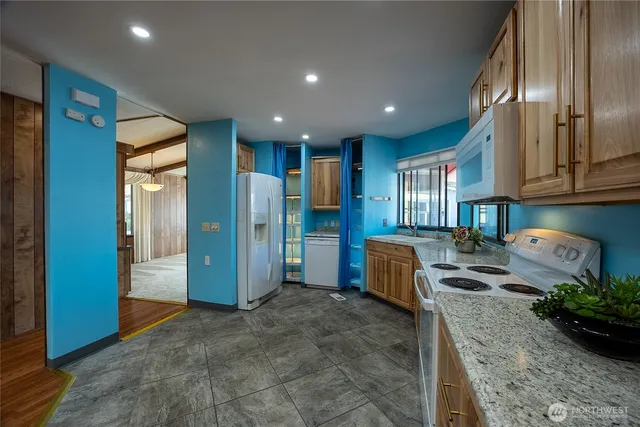 a kitchen with stainless steel appliances granite countertop a refrigerator and a stove