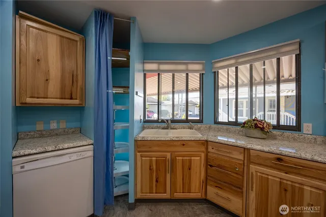 a utility room with granite countertop cabinets washer and dryer
