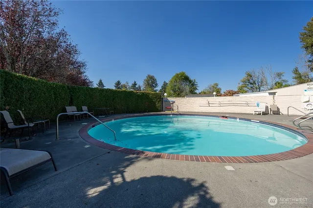 a view of a swimming pool with a yard and outdoor seating