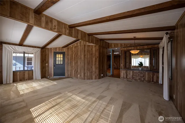 a view of a hallway with wooden floor and a living room