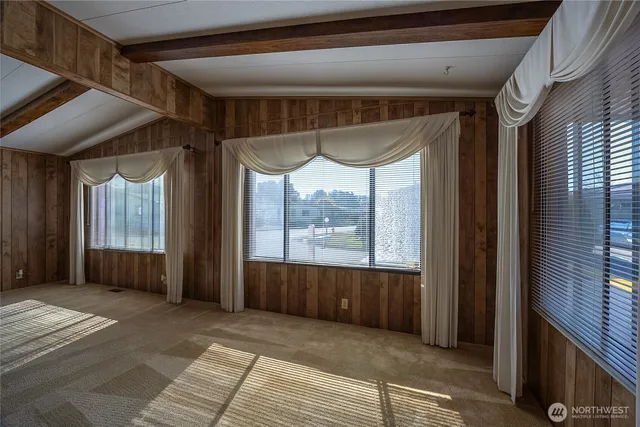 a view of a room with a large window and wooden floor