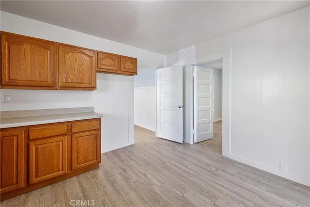a view of a kitchen with wooden floor and cabinets
