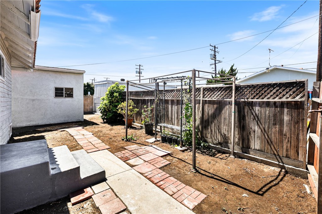 15323 Paramount Boulevard Paramount, CA 90723 - Photo 32 of 72 a view of a patio with table and chairs with wooden floor and fence
