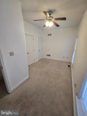 an empty room with chandelier fan